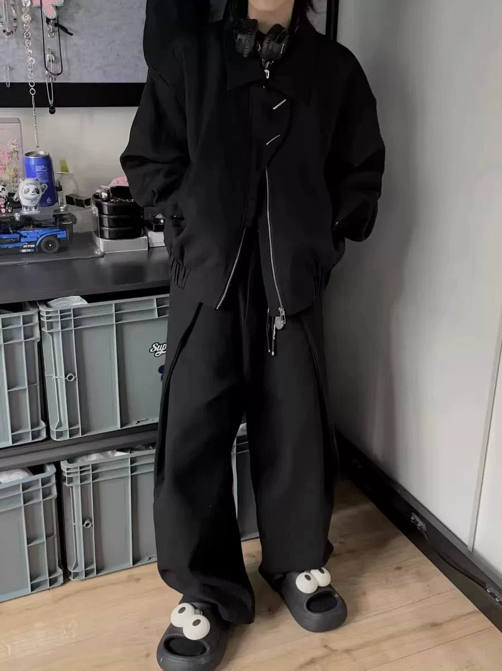 Side view of men's matte black oversized bomber jacket with relaxed sleeves and minimalist asymmetrical collar detail