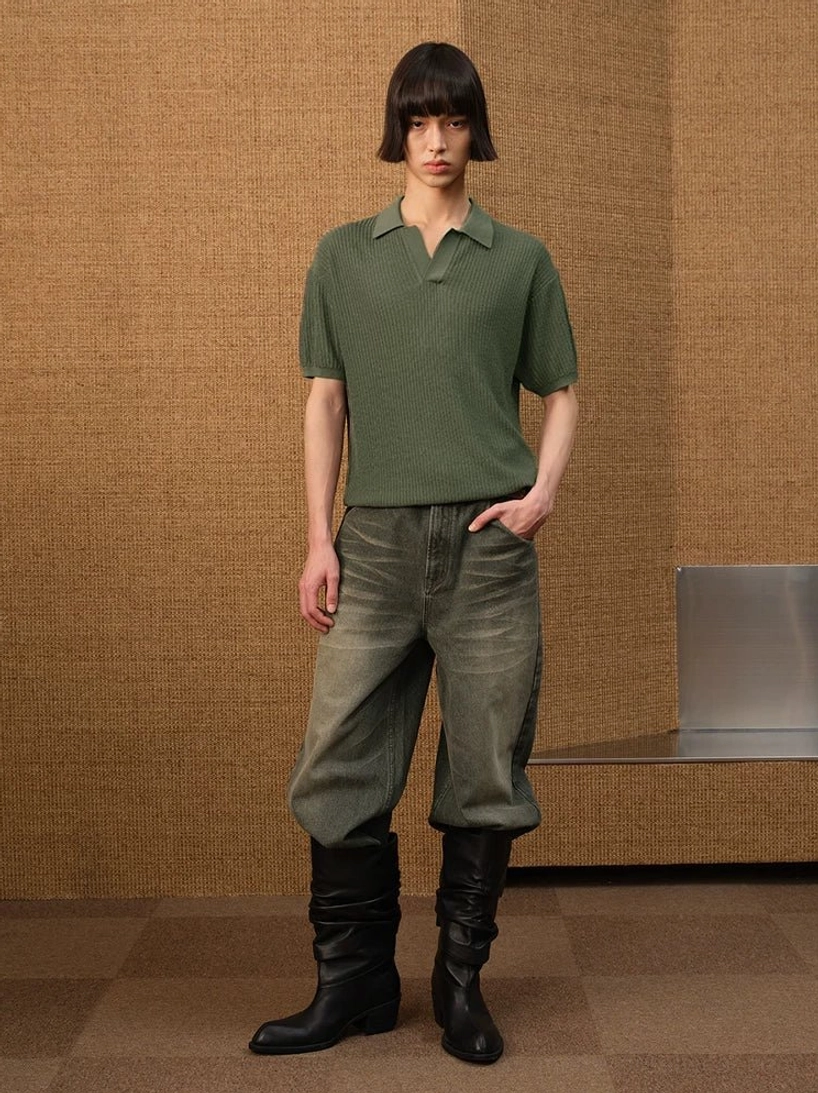 Men's olive green textured knit open-collar polo shirt styled with cropped faded jeans and black knee-high boots