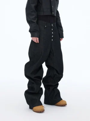Three-quarter front view of men's oversized black streetwear jeans featuring a high waist, multi-button fly, relaxed wide legs, and dark denim texture