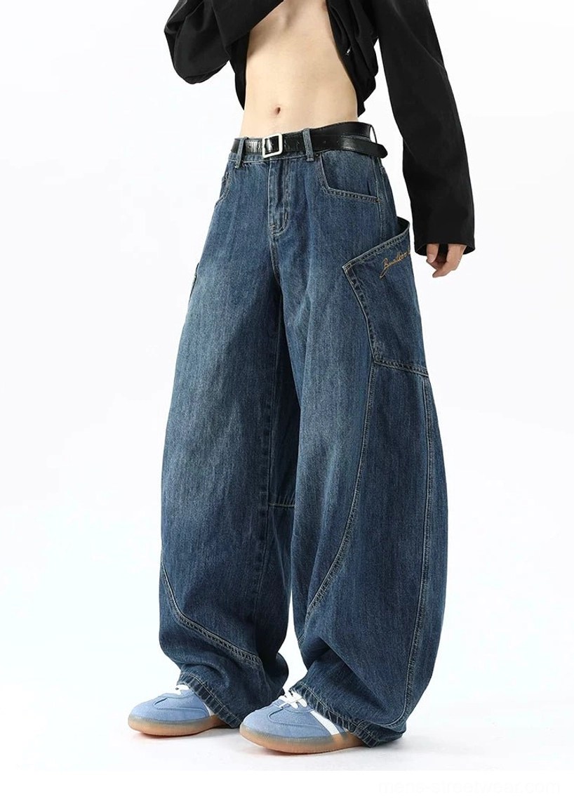Men's oversized blue balloon cargo jeans styled with black long sleeve top showing wide denim silhouette and side utility pocket