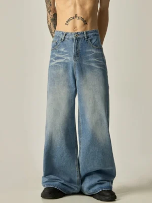 Front full-body view of men's oversized vintage wash blue wide-leg denim jeans with faded thigh details