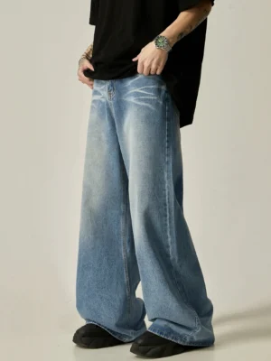 Side view of oversized vintage wash blue wide-leg jeans styled with a black oversized t-shirt and platform loafers