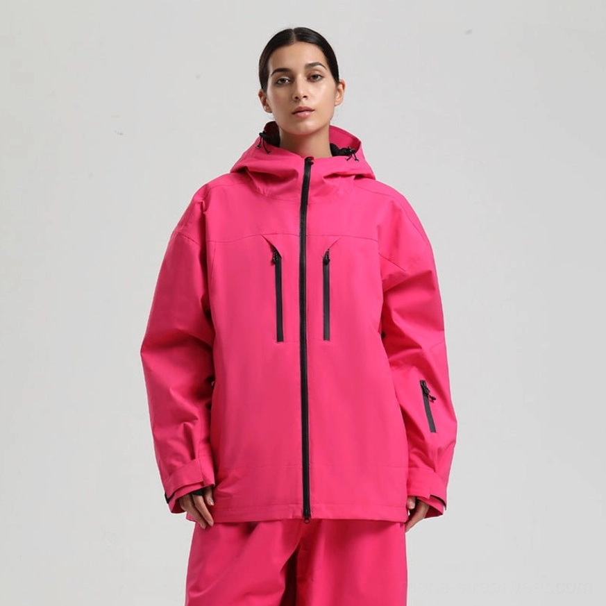 Bright hot pink hooded ski jacket with black zipper details and a relaxed fit, modeled with matching pink snow pants