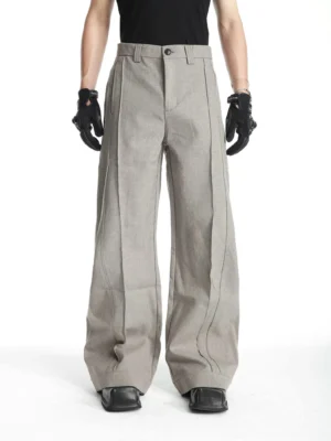 Men's heather gray pleated barrel-leg tailored trousers styled with black t-shirt gloves and square-toe shoes front full-body view