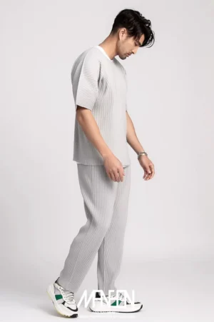 Light grey men's pleated boxy tee styled with matching straight-leg trousers in a minimalist Korean streetwear studio look