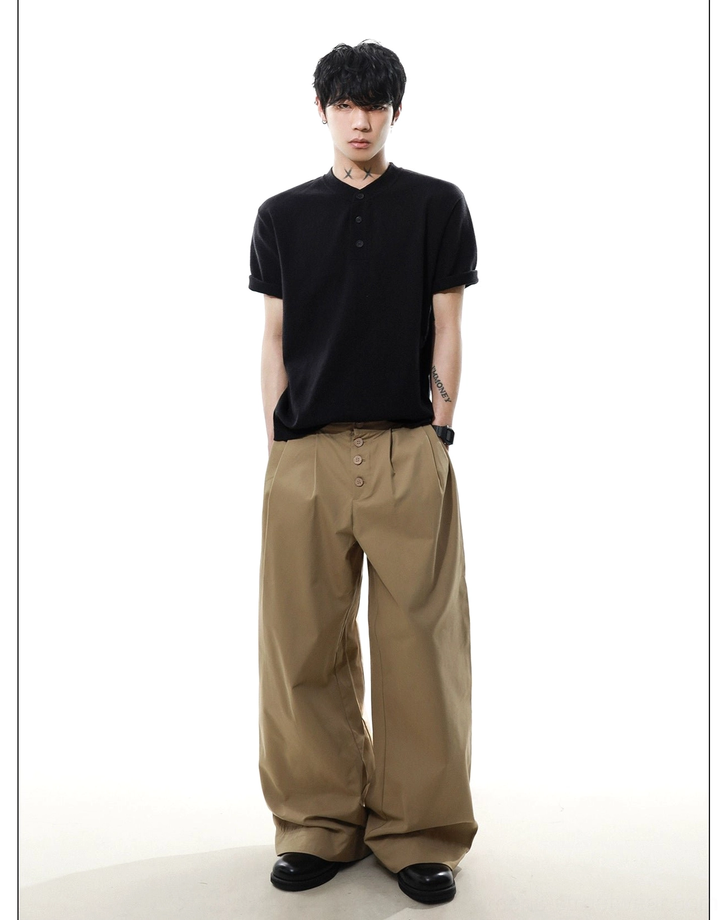 Full body view of black men's relaxed knit Henley T-shirt paired with khaki trousers for Korean streetwear styling
