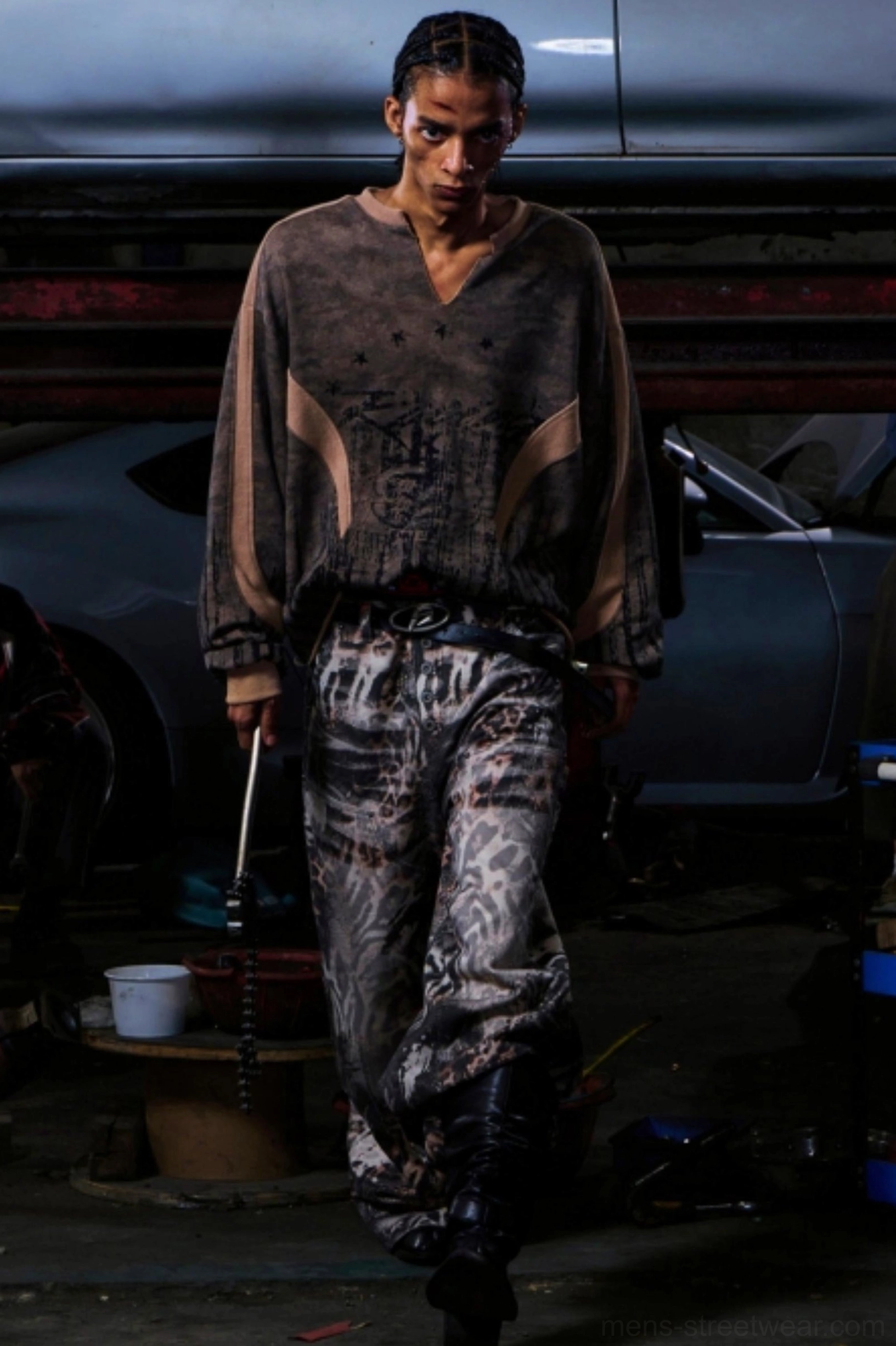 Men's relaxed oversized camouflage half-zip streetwear outfit styled with work boots and wide-leg printed trousers