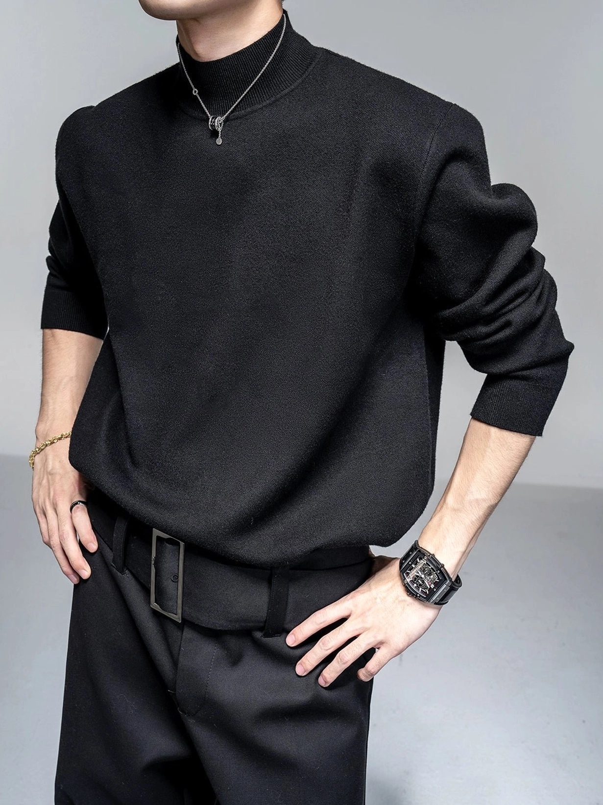 Black men's mock neck knit sweater with silver pendant and black trousers in monochrome Seoul streetwear look