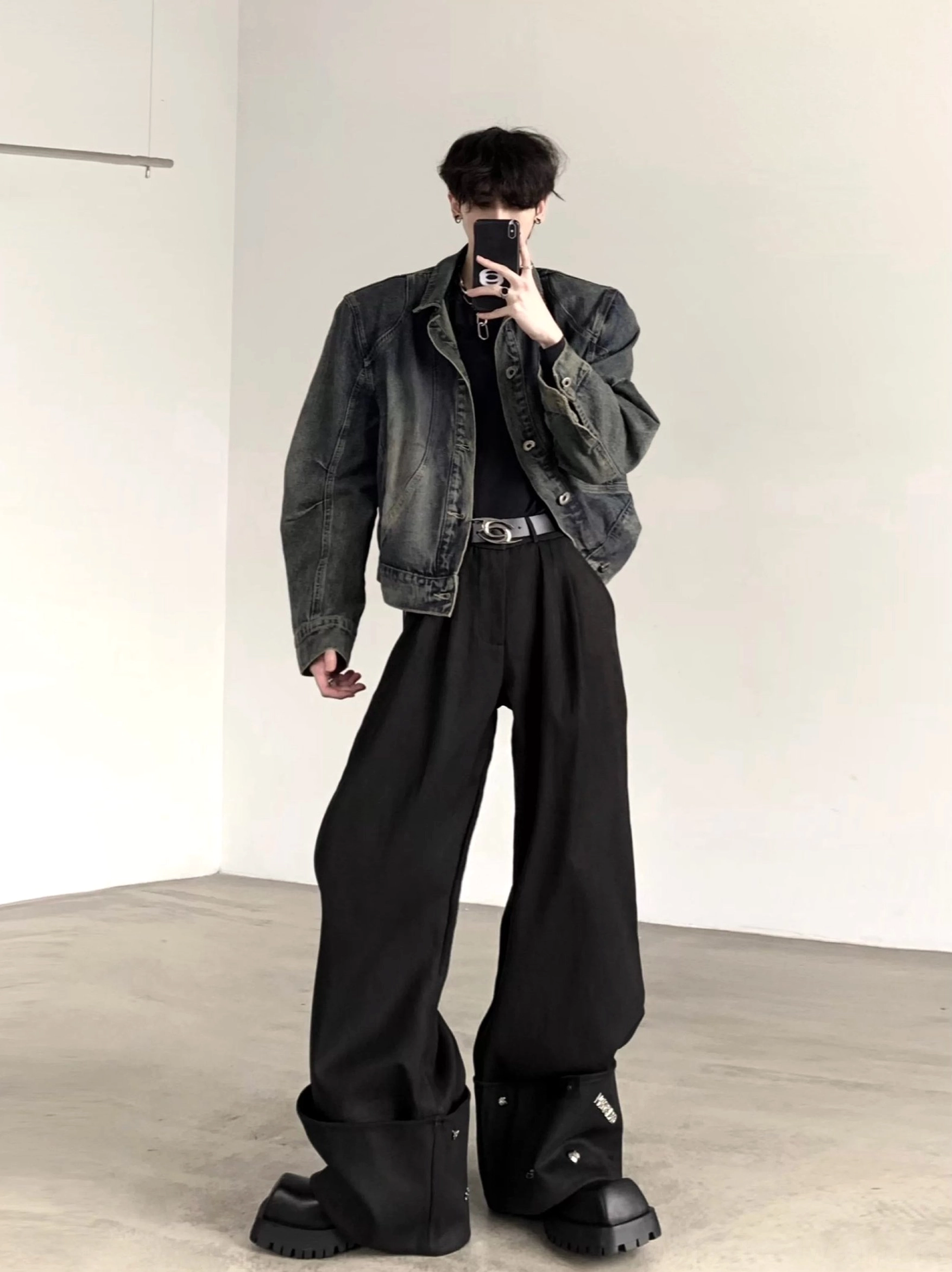 Men's cropped boxy washed blue denim jacket with structured shoulders styled with black wide-leg trousers in a mirror selfie