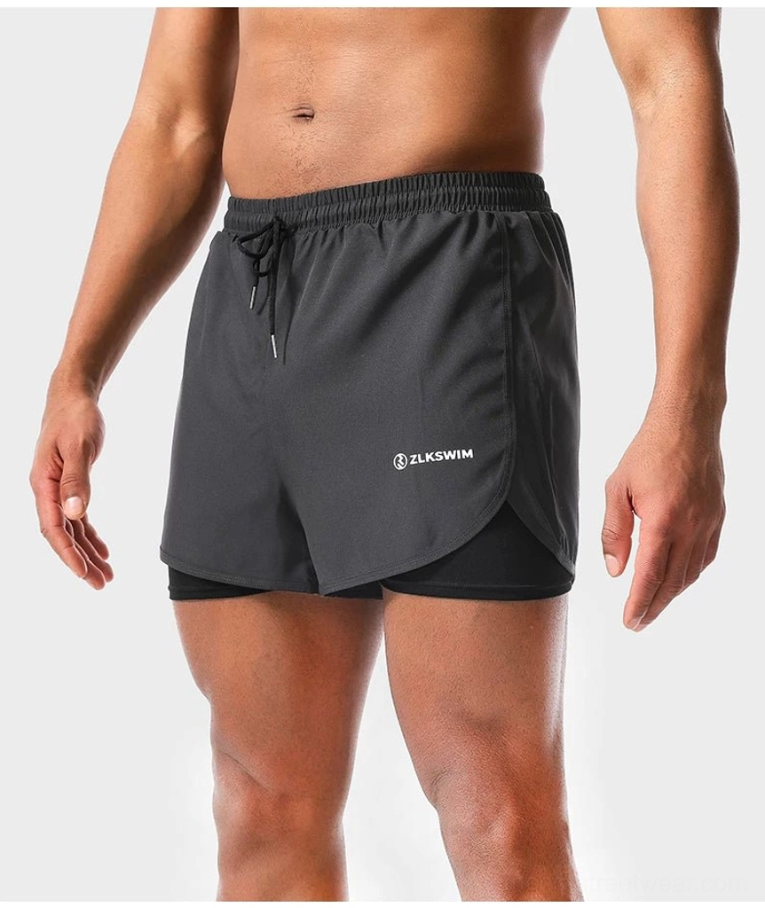 Dark gray men's double-layer swim shorts close-up featuring curved hem quick-dry fabric and inner coverage liner