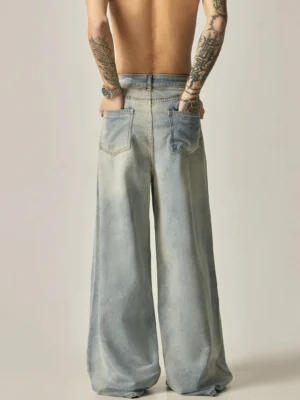 Rear full body view of men's bleached denim ultra-wide leg jeans with patch pockets and vintage blue wash