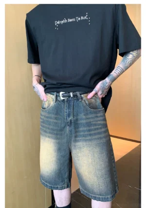 Men's vintage faded distressed denim shorts yellow wash straight leg fit oversized black graphic tee indoor front view full body
