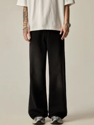 Men's washed black wide-leg denim jeans front full-body view styled with oversized white t-shirt and silver sneakers