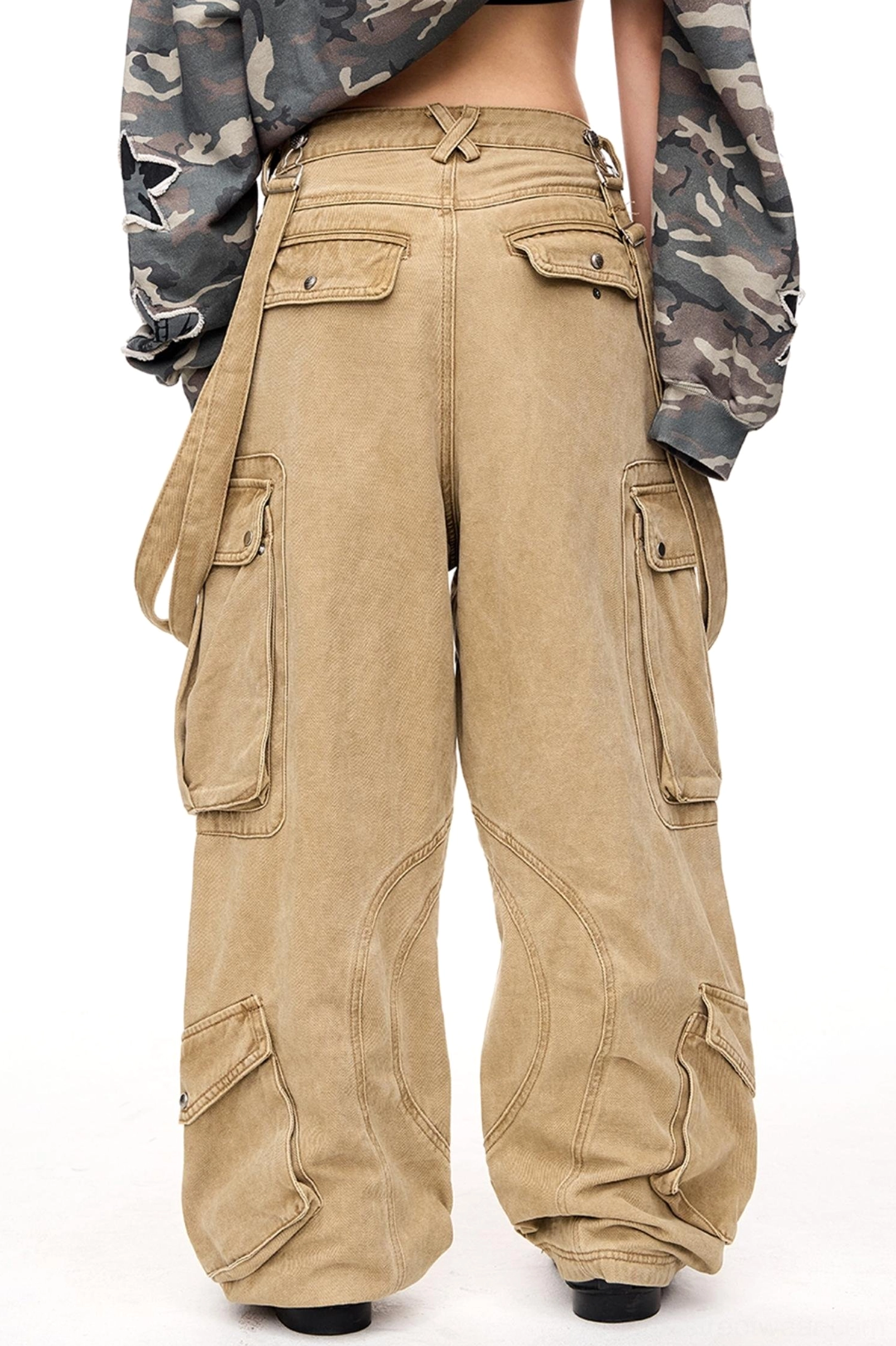 Back three-quarter view of men's washed tan cargo pants with crisscross rear waist detail, side utility pockets, and relaxed vintage streetwear fit