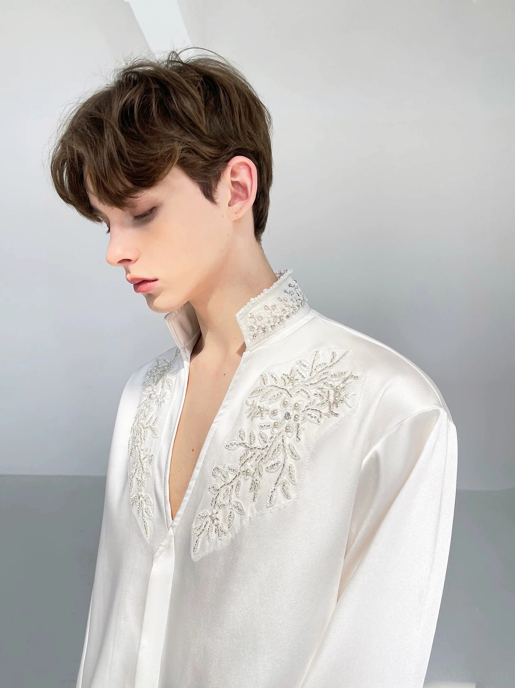 Side front view of men's white satin shirt with beaded stand collar and detailed floral chest embroidery