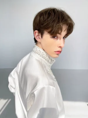 Men's white beaded floral embroidered satin shirt shown from the rear three-quarter view with glossy fabric and stand collar