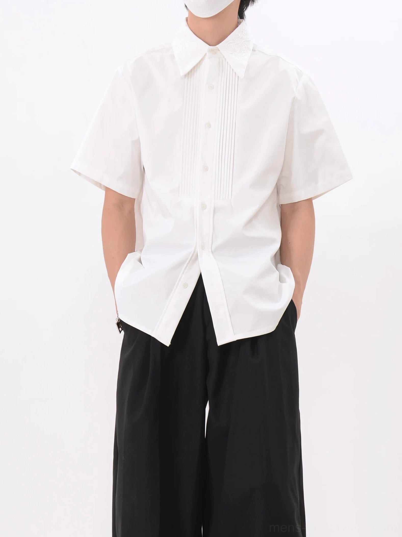 Three-quarter view of white men's relaxed fit pleated tuxedo shirt with clean pointed collar and short sleeves