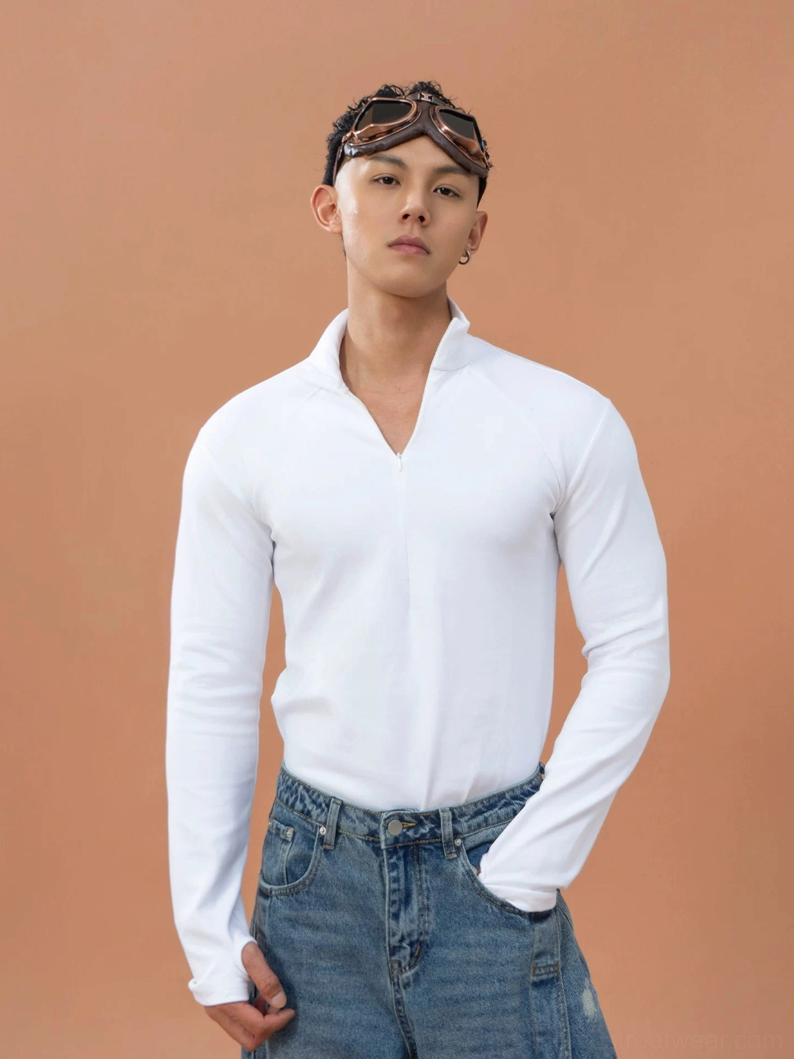 White men's slim-fit quarter-zip stretch top with stand collar and long raglan sleeves styled with blue denim jeans