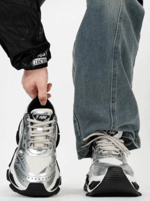 Liquid silver metallic platform dad sneakers shown from the front with layered overlays, breathable mesh panels, chunky black sole and futuristic streetwear styling