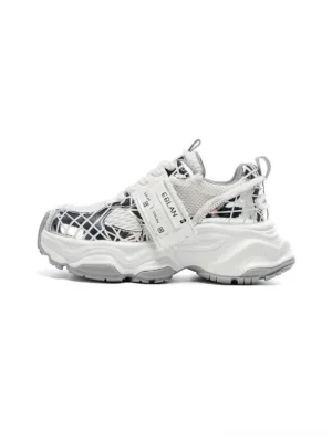 Metallic silver mesh tech runner sneaker in rear three-quarter view with reflective grid overlays and chunky sculpted rubber outsole