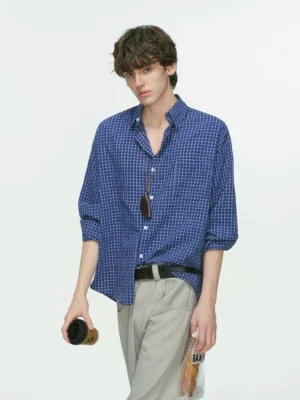 Royal blue and white grid plaid Korean streetwear shirt with relaxed silhouette, rolled sleeves, wide-leg gray trousers, and sunglasses