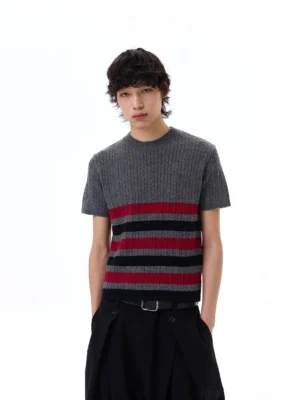 Front full-body view of a grey striped ribbed knit tee with red and black horizontal chest stripes styled with black wide-leg trousers
