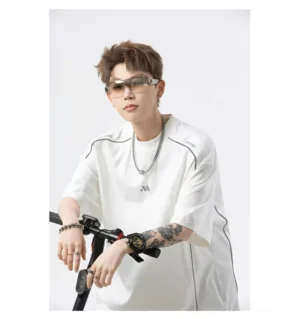 White oversized techwear T-shirt with black contrast seam piping and minimal chest logo, styled on a male model beside an electric scooter