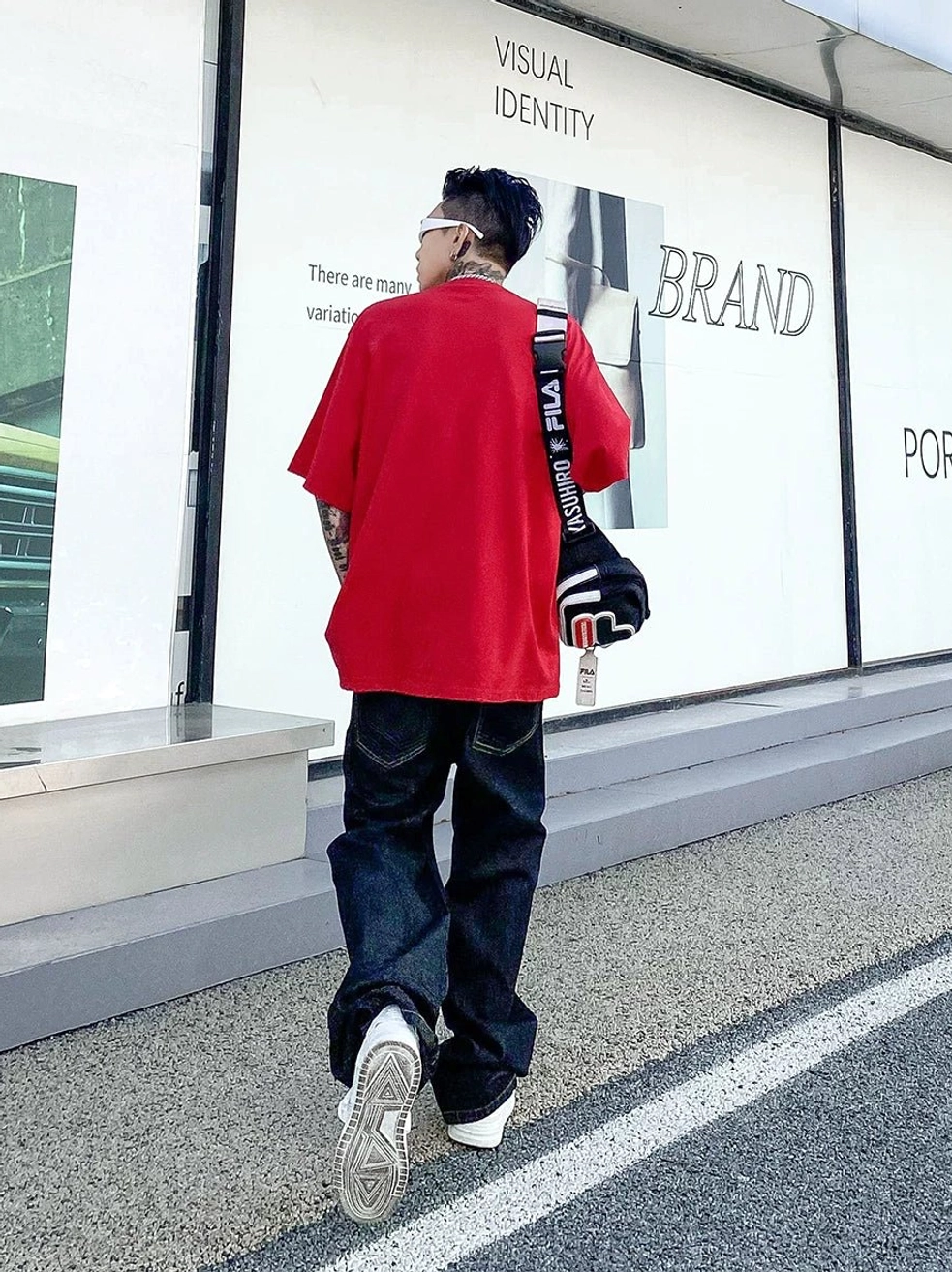 Back view of midnight fade relaxed straight leg dark indigo jeans styled with oversized red t shirt and crossbody bag