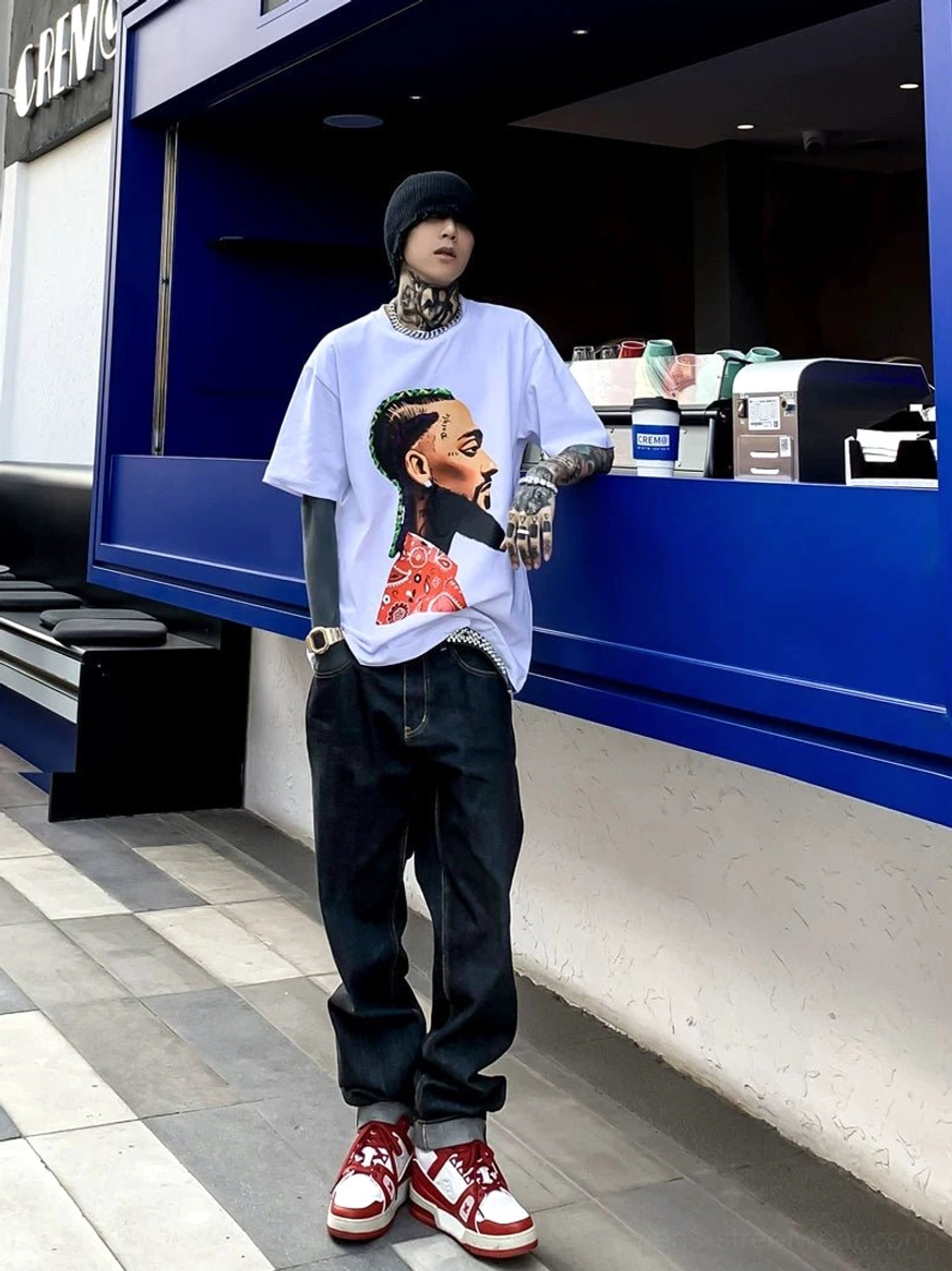 Dark indigo relaxed straight leg jeans paired with graphic t shirt beanie and retro sneakers at urban coffee stall