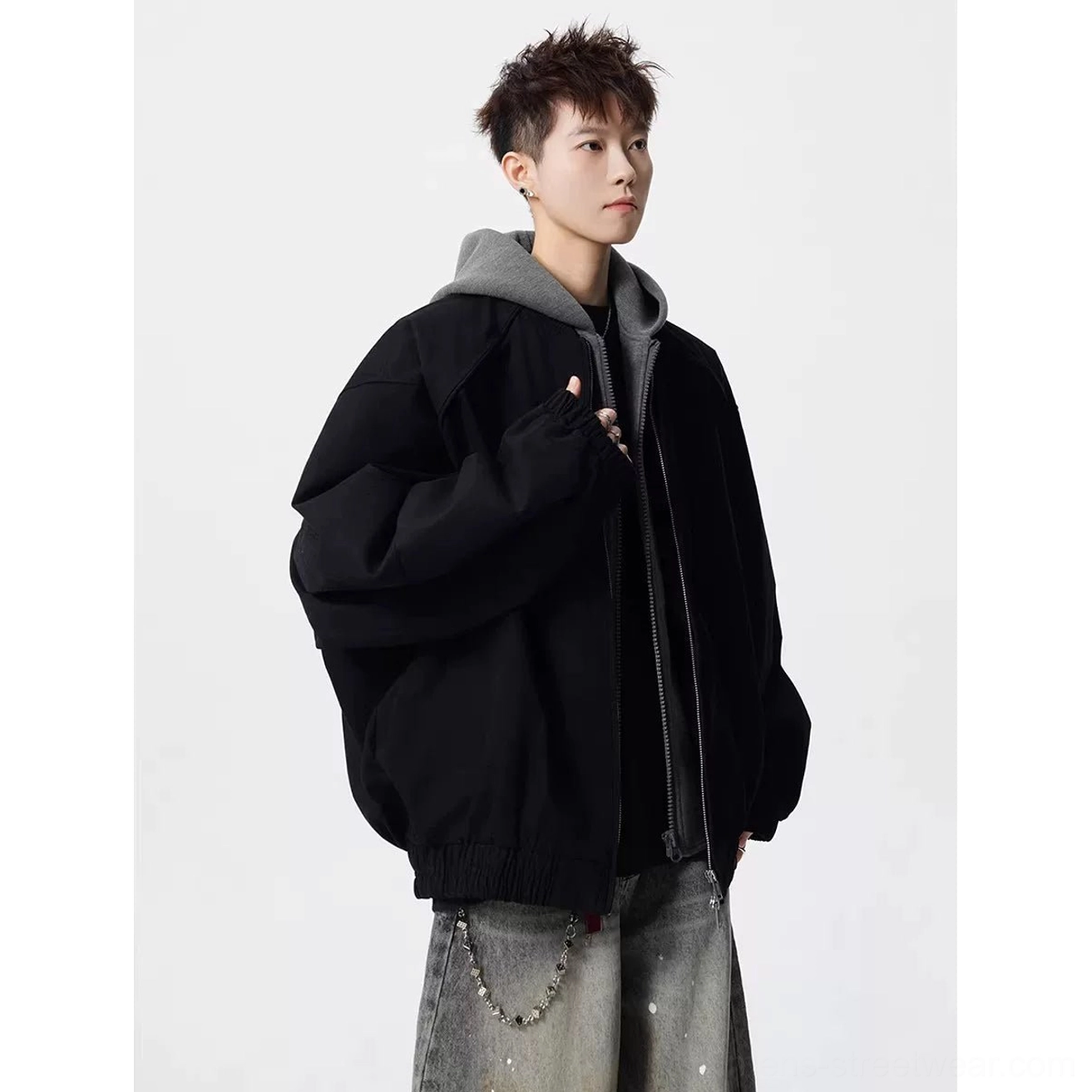 Black oversized layered hooded bomber jacket with grey hood detail in three-quarter front streetwear styling