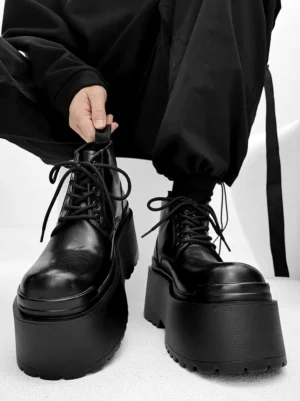 Black lace-up ultra platform ankle boots with polished leather toe and oversized sole in avant-garde streetwear styling