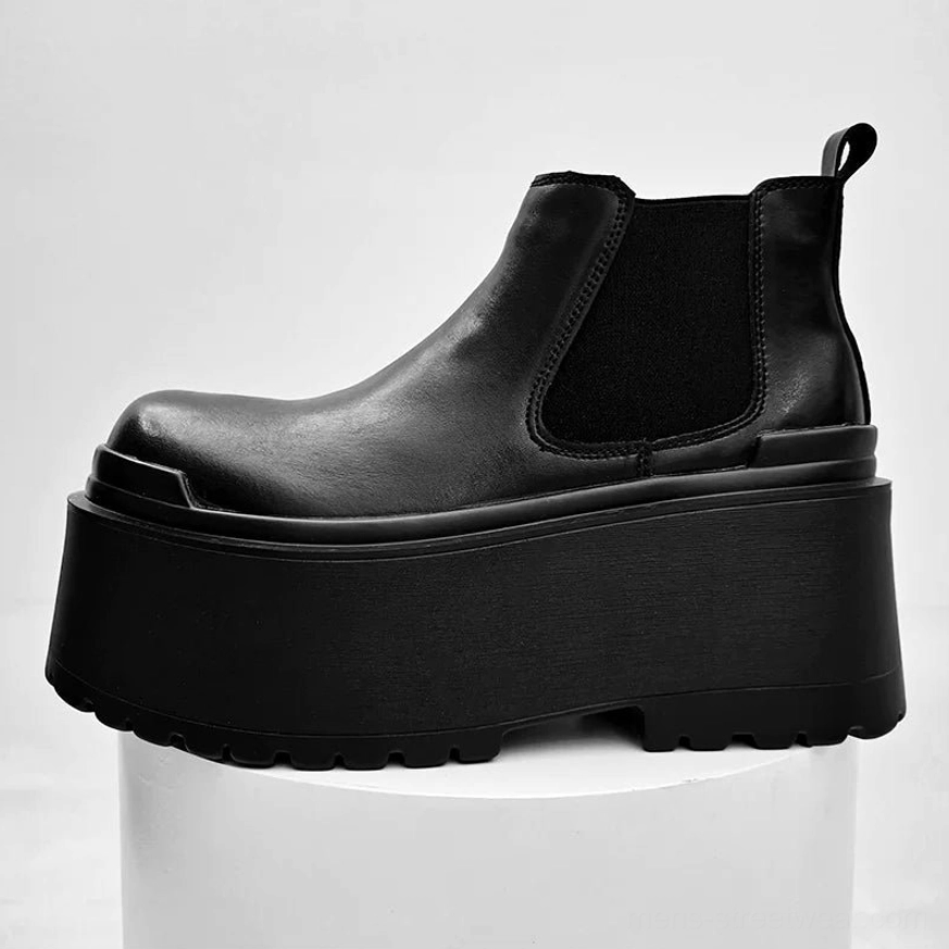Black ultra platform Chelsea ankle boots on white studio pedestal with smooth leather elastic panels and chunky sole