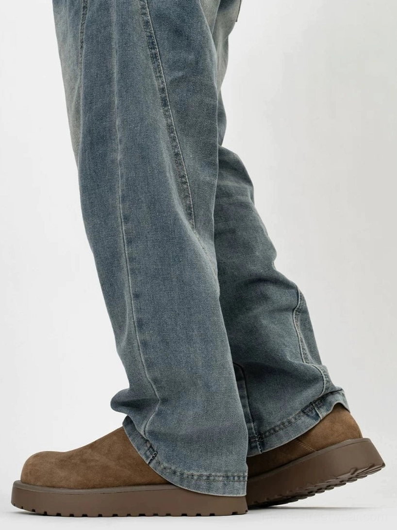 Brown suede-style platform slip-on clogs worn with washed denim showing the chunky dark rubber midsole and relaxed streetwear fit