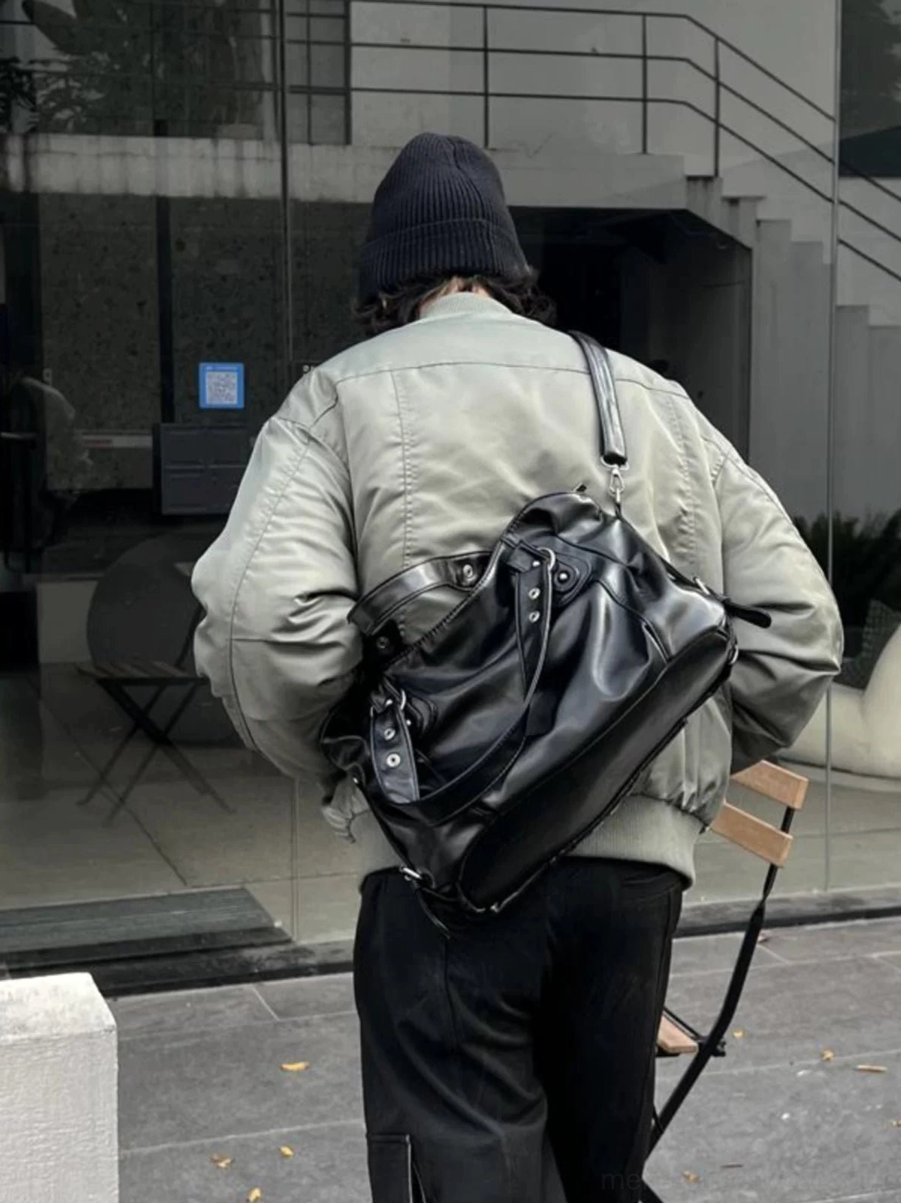 Midnight rivet faux leather streetwear crossbody tote bag worn on the back with grey bomber jacket