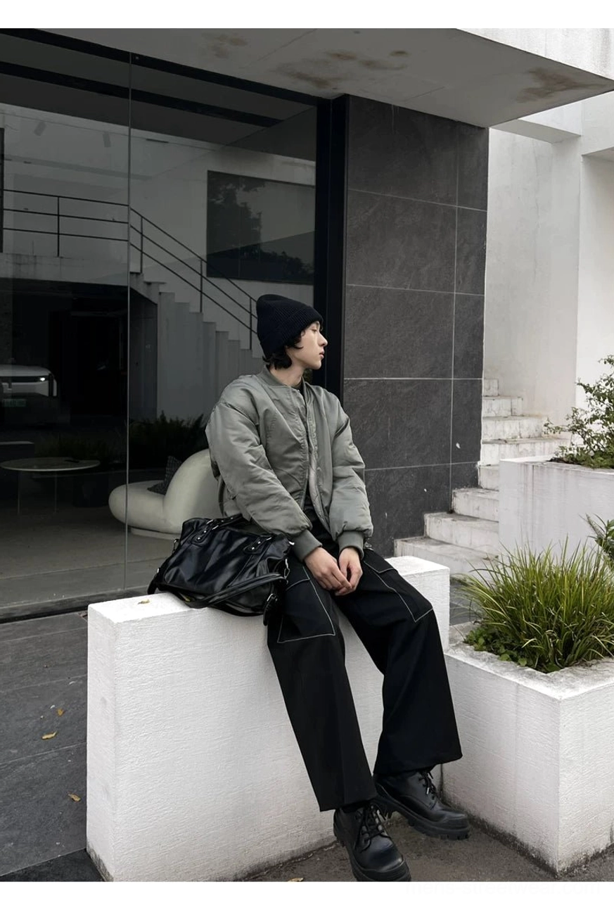 Midnight rivet black faux leather tote bag styled as a low crossbody bag beside a seated model