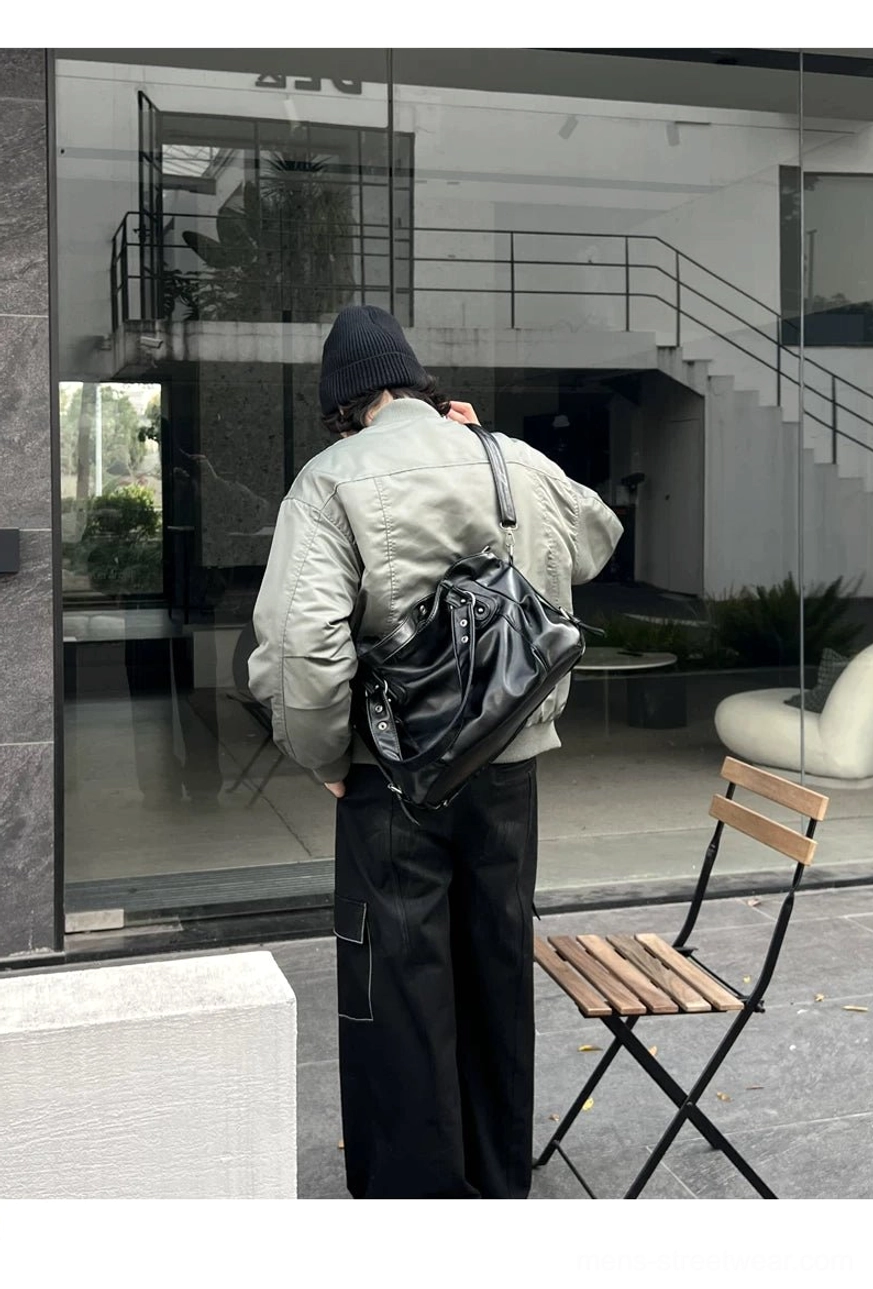 Midnight rivet oversized faux leather streetwear tote bag worn outdoors against a modern glass building