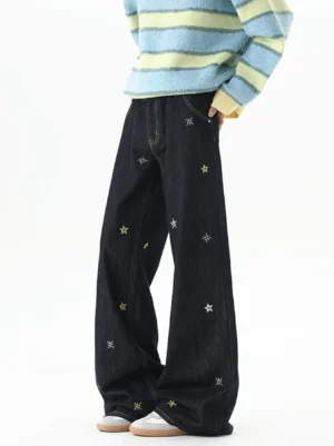 Side front view of dark blue wide-leg denim jeans with scattered yellow and silver star embroidery