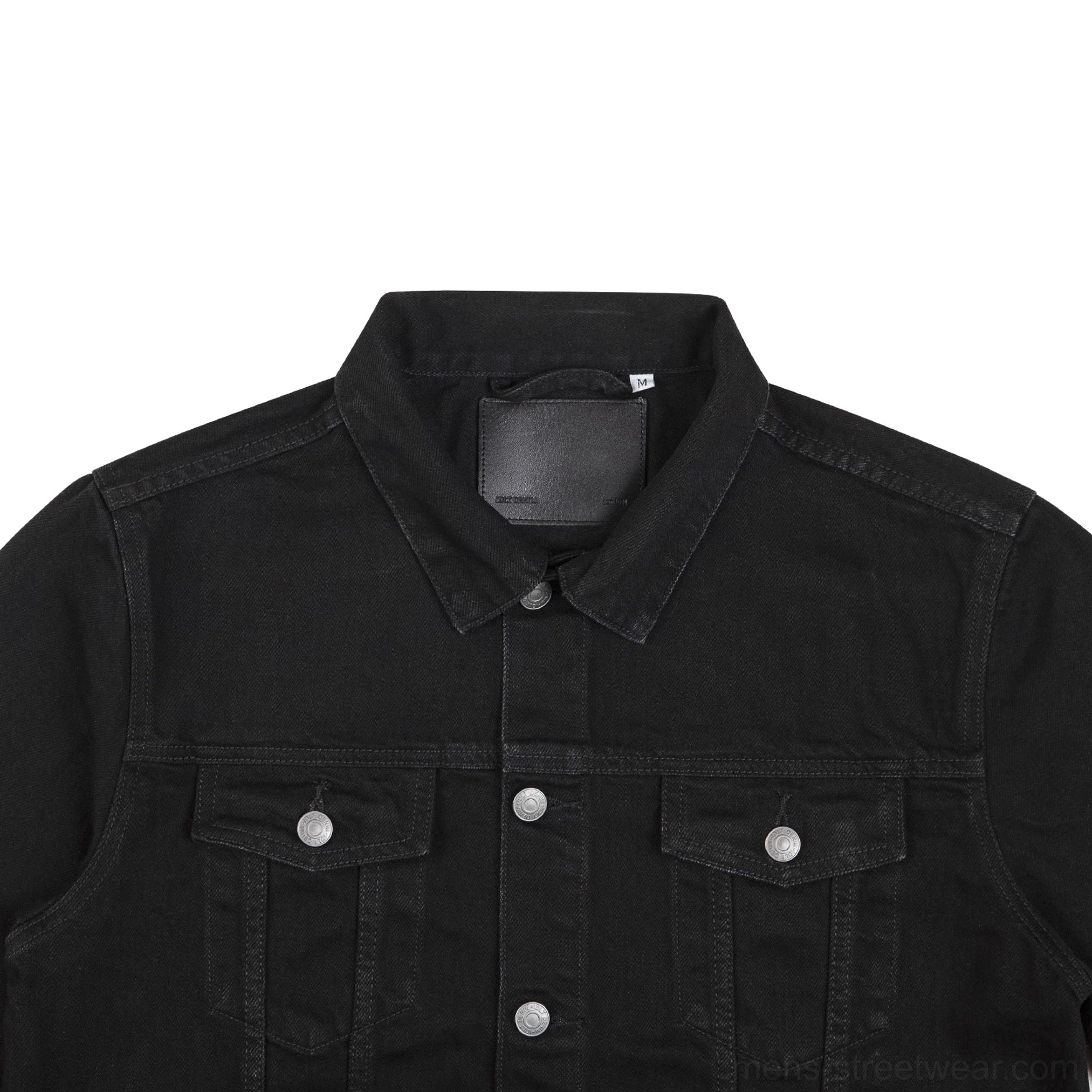 Close-up of washed black denim trucker jacket collar silver snap buttons and textured cotton denim fabric