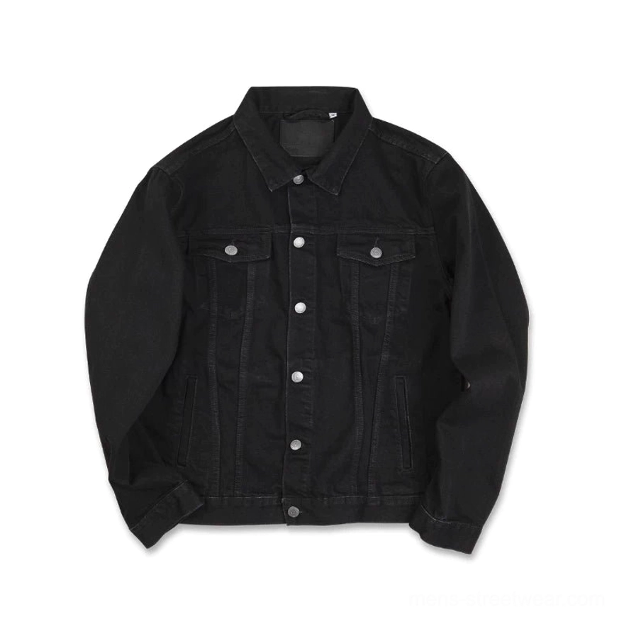 Relaxed front flat lay of midnight black cotton denim trucker jacket with snap closure and dual chest pockets