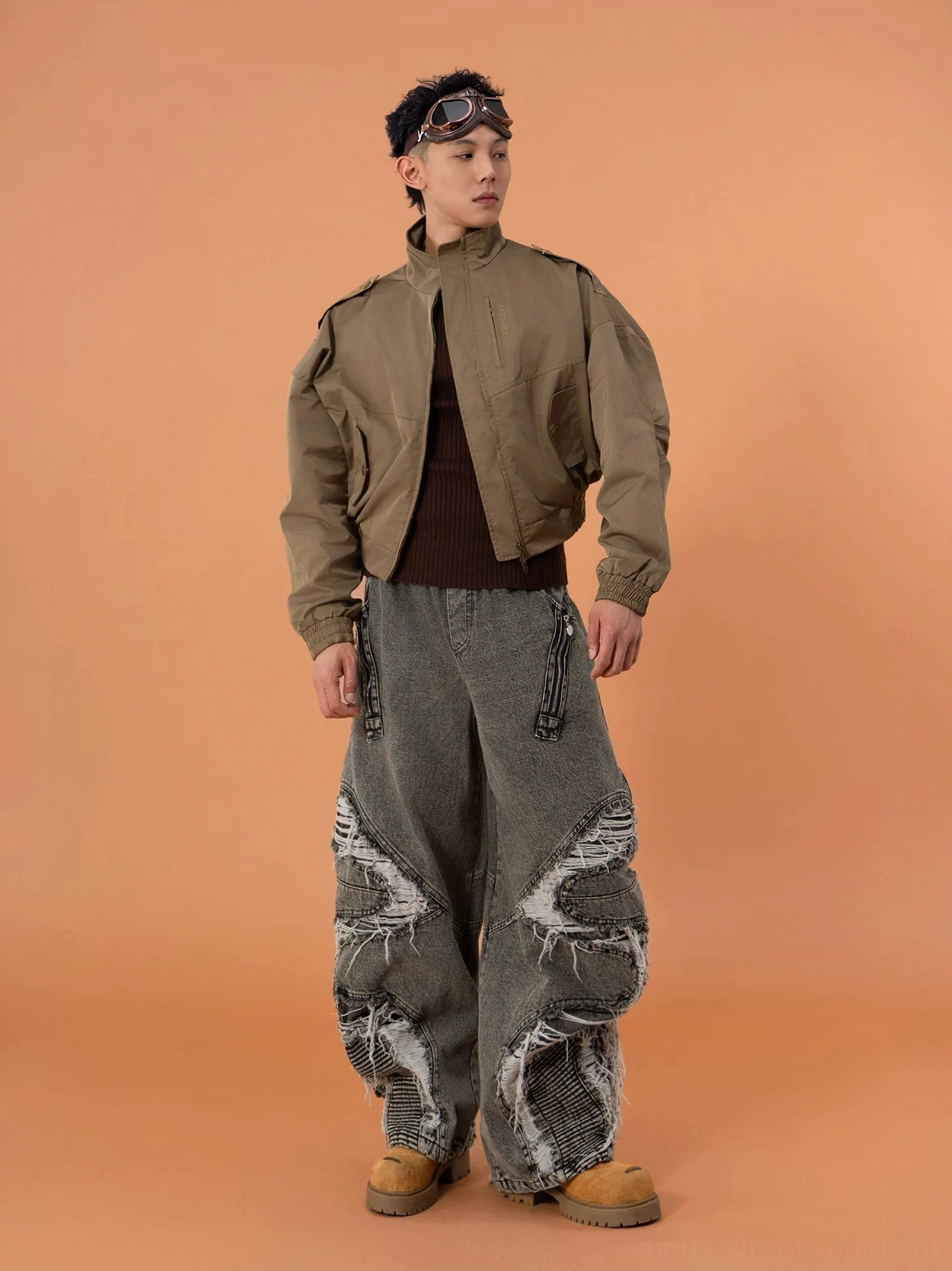 Side view of a military green cropped bomber jacket with high stand collar relaxed cropped silhouette long elasticated cuffs and oversized sleeves