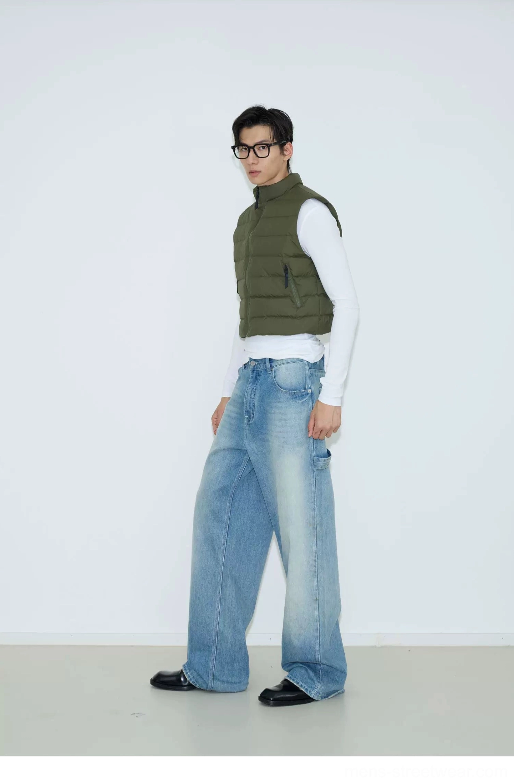 Military green cropped puffer vest with horizontal quilting and stand collar shown in a side profile