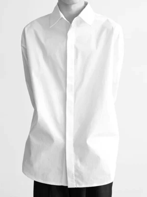 White oversized cotton poplin shirt with concealed button placket and pointed collar front studio view