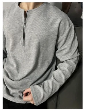 Close-up of a heather gray waffle knit half-zip sweatshirt with stacked cuffs and minimalist Korean streetwear styling