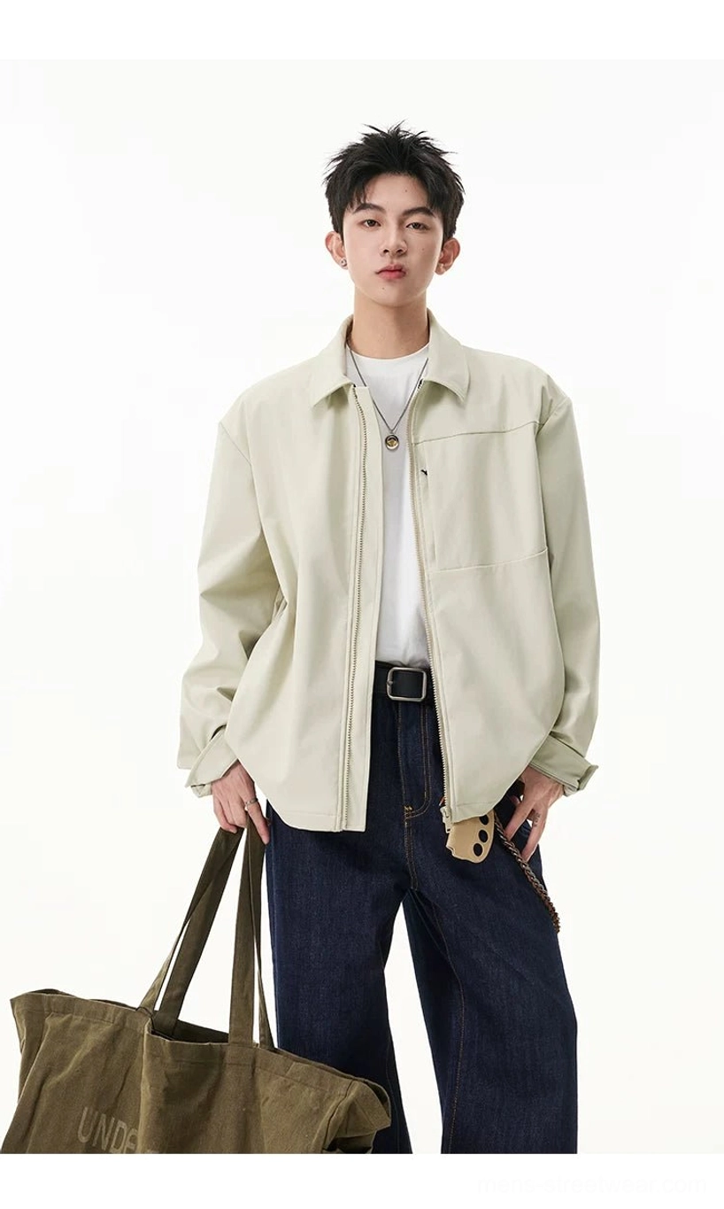 Men's pale beige zip shirt jacket styled with white top, dark jeans, leather belt, necklace, and canvas tote