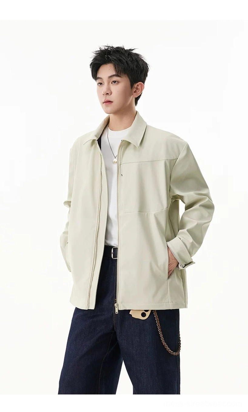 Three-quarter view of men's pale beige zip shirt jacket styled with white tee, dark denim, and wallet chain