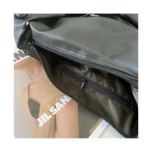 Interior view of black minimalist PU leather tech sling bag showing polyester lining inner zip pocket and top zipper