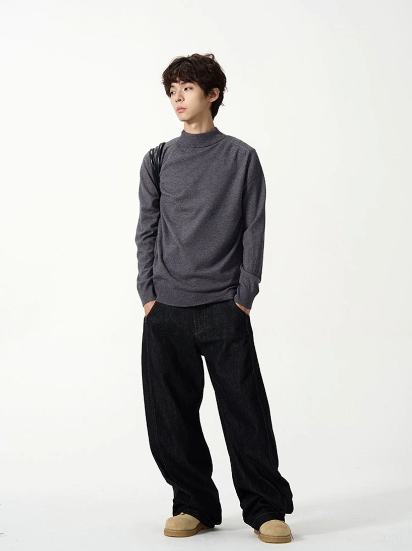 Dark gray relaxed fit mock neck knit sweater side view styled with wide leg black jeans and casual shoes