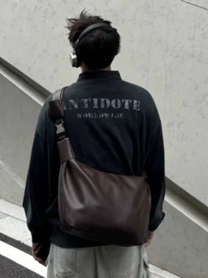 Dark brown minimalist PU leather streetwear crossbody shoulder sling bag worn across the back with cargo pants