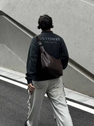 Dark brown PU leather streetwear shoulder sling bag side back wearing view with wide strap and cargo pants