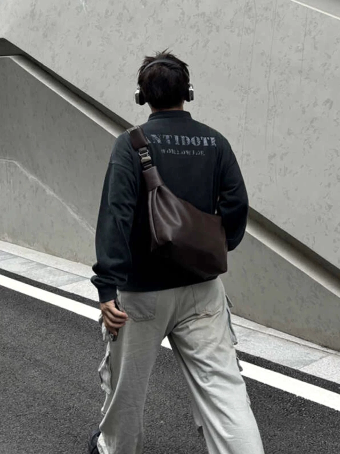 Dark brown PU leather streetwear shoulder sling bag side back wearing view with wide strap and cargo pants